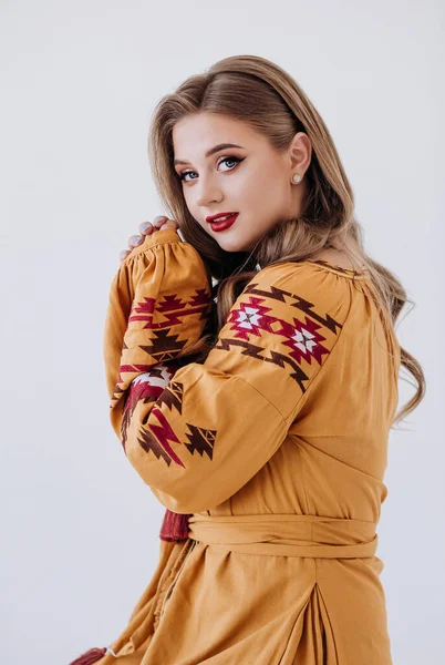 Young beautiful girl in a embroider dress. Traditional Ukrainian wear Vyshyvanka. White background