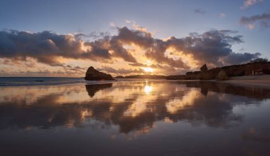 Gelgit sularına yansıyan manzara. Portekiz, Portimao 'daki Beach Tres Castelos.