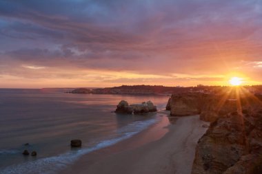 Portekiz 'in Algarve kıyısındaki Praia do Amado' da gün batımı. Uzun pozlama resmi