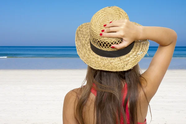 Meisje houdt de hoed met de beach-achtergrond — Stockfoto