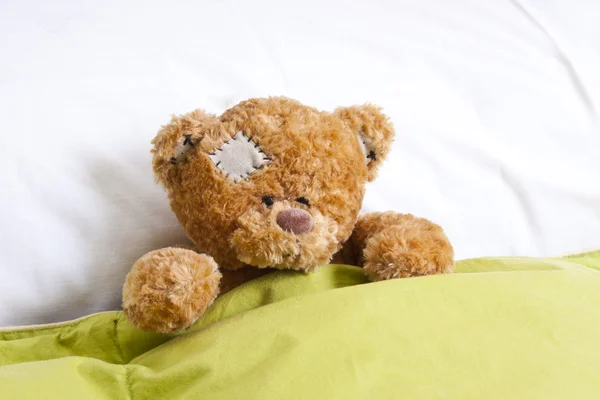 Teddy bear on the bed in the room — Stock Photo, Image