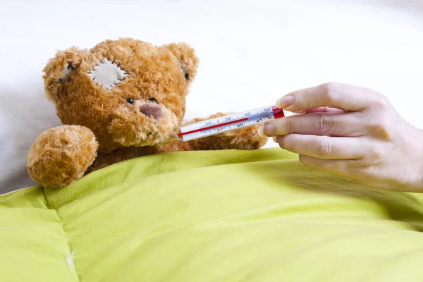 Teddy bear on the bed in the room — Stock Photo, Image