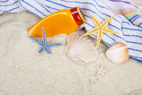 Csillagok, toalla y protector solar en la playa — Stock Fotó