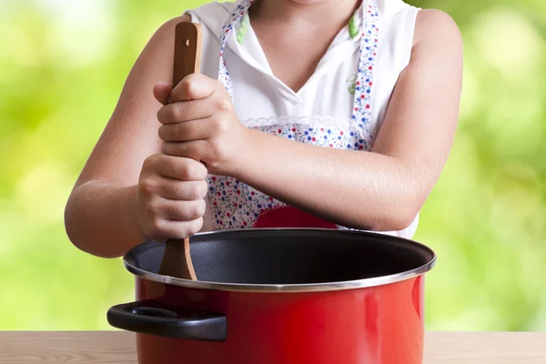 Young girl in the kitchen with chef clothing — Stock Photo, Image