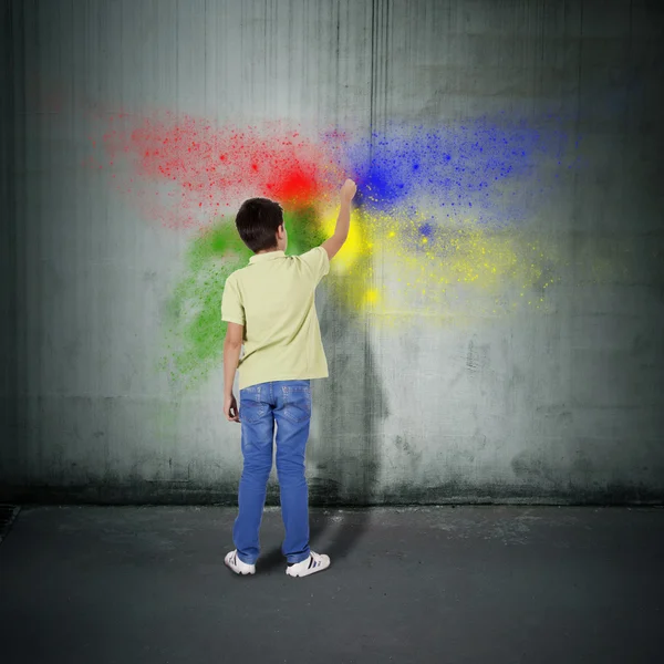 Ragazzo pittura sul muro con colori — Foto Stock