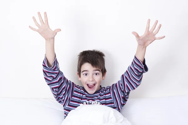 Garoto sorridente na cama acordando e cumprimentando — Fotografia de Stock