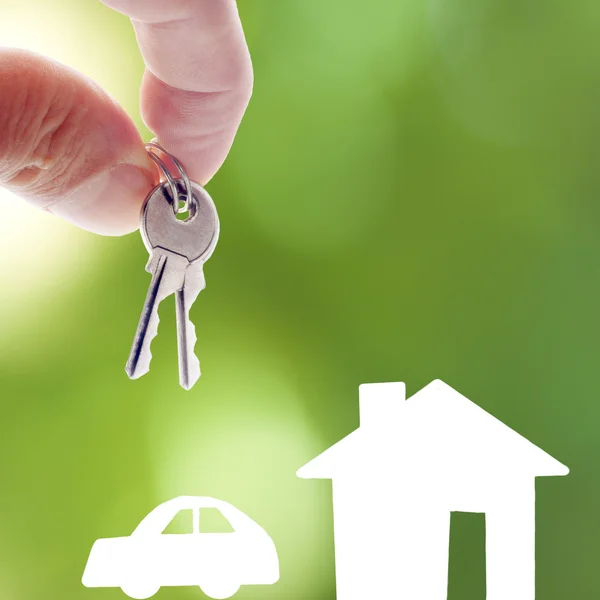 Hand mit Schlüsseln und Autozeichnungen und das Haus — Stockfoto
