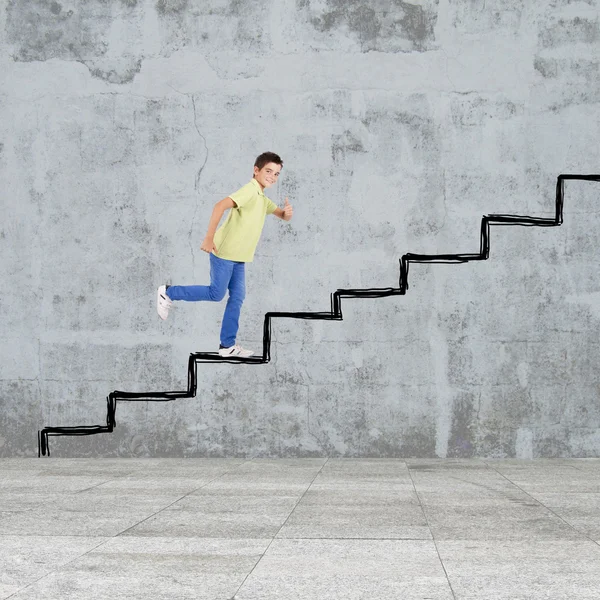 Fiatal fiú szedi a lépcsőket, levonni a falon — Stock Fotó