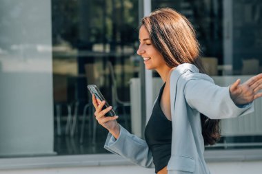 Şehir caddesinde cep telefonu olan bir kız.