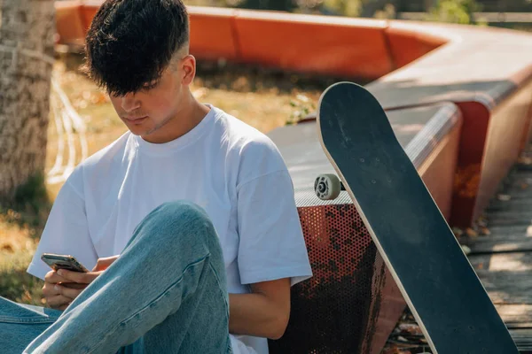 Tiener Jongen Met Mobiele Telefoon Skateboard Straat — Stockfoto