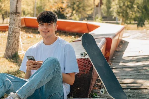 Tonåring Med Mobiltelefon Och Skateboard Utomhus — Stockfoto