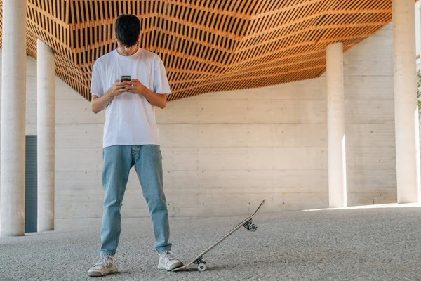 Ung Tonåring Pojke Med Mobiltelefon Och Skateboard — Stockfoto