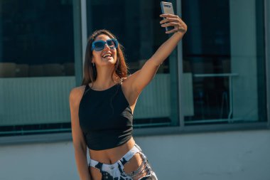 Cep telefonlu kız fotoğraf çekiyor.