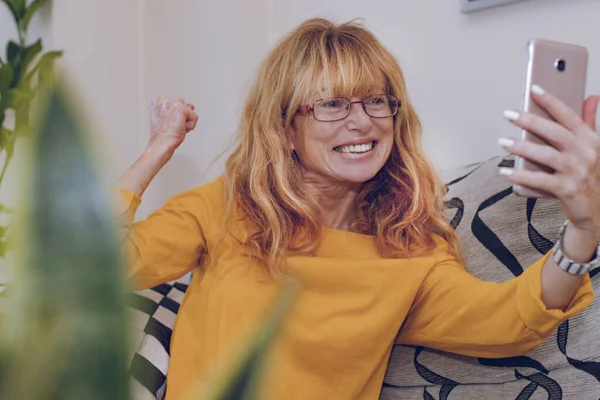 woman celebrating looking at mobile phone