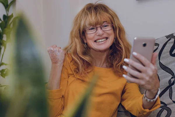 Kobieta Świętuje Patrząc Telefon Komórkowy — Zdjęcie stockowe