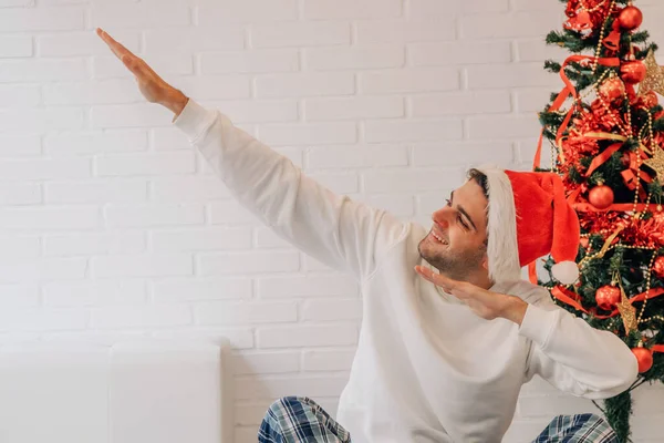 Homem Casa Natal Com Chapéu Papai Noel Gesto Divertido — Fotografia de Stock