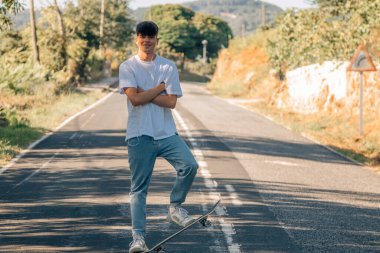 Yoldaki kaykaylı genç çocuk.