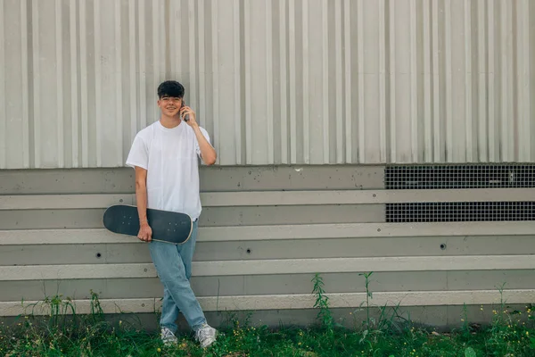 Dospívající Chlapec Mobilním Telefonem Skateboardem — Stock fotografie
