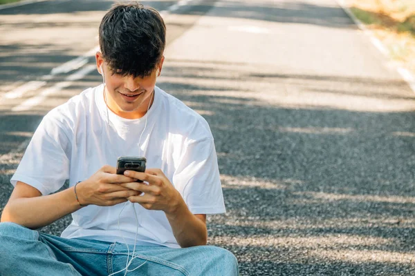 Tonårspojke Med Mobiltelefon Sittande Golvet — Stockfoto