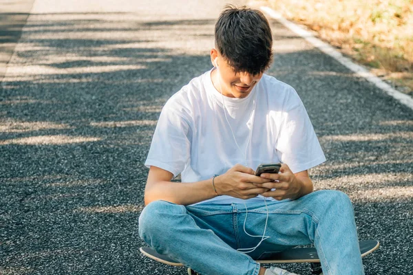 Tonårspojke Med Mobiltelefon Sittande Golvet — Stockfoto
