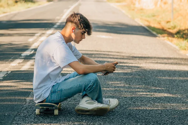 Tonårspojke Med Mobiltelefon Och Skateboard Vägen — Stockfoto