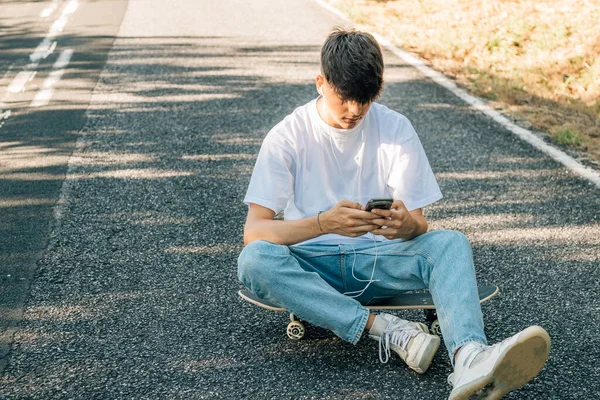 Tonårspojke Med Mobiltelefon Sittande Golvet — Stockfoto