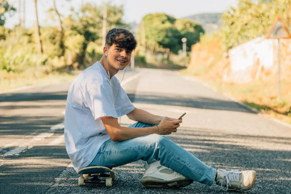 Adolescente Con Teléfono Móvil Monopatín Carretera — Foto de Stock