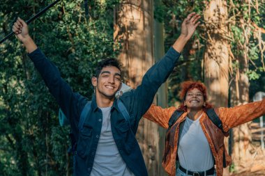 Sırt çantalı mutlu bir çift gezintiye çıkar ya da yürüyüş talimi yapar.