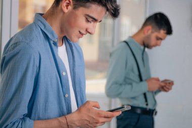 Gençler cep telefonuna bakıyor