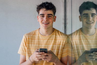 Cep telefonlu genç yansıma ve kopyalama alanı ile eğiliyor