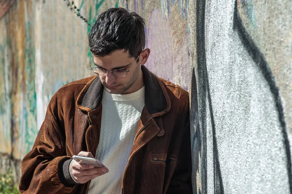 Jonge Man Herfst Kleding Met Mobiele Telefoon Aan Muur — Stockfoto