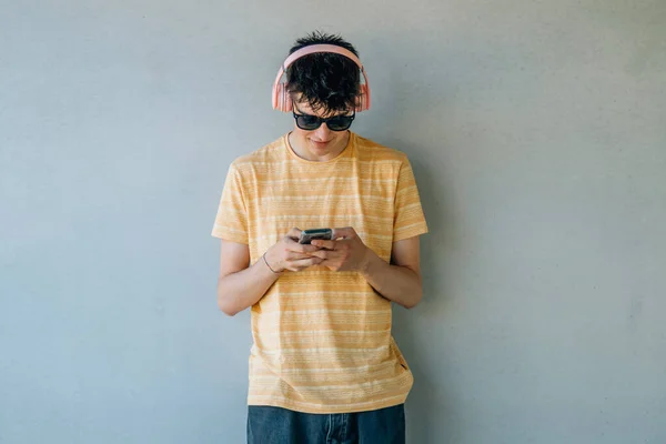 Duvarında Kulaklık Cep Telefonu Olan Genç Bir Çocuk — Stok fotoğraf