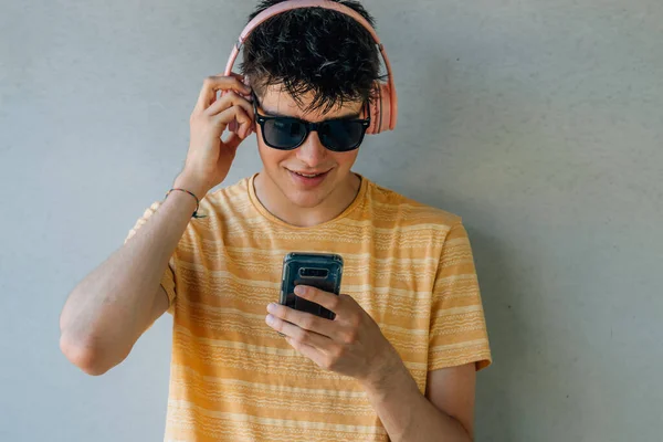 Adolescente Con Auriculares Teléfono Móvil Pared — Foto de Stock