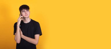 Cep telefonu ya da cep telefonuyla konuşan izole bir genç çocuk.