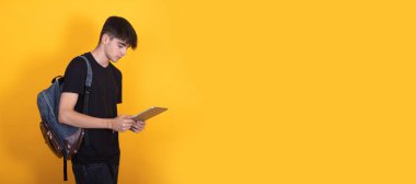 Sırt çantası ve dijital tabletle izole öğrenci