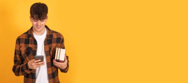 Cep telefonu olan öğrenci sarı arkaplanda izole edildi