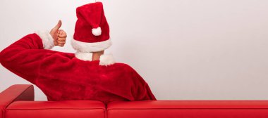 Noel Baba kanepede oturuyor ve üzerinde 