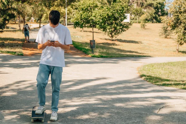 Teenager Mit Handy Und Skateboard Auf Der Straße — Stockfoto