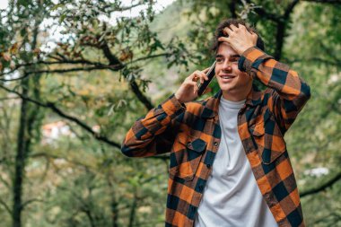 Sonbaharda dışarıda cep telefonuyla konuşan çocuk.