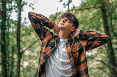 Genç adam dışarıda rahatça eğleniyor.