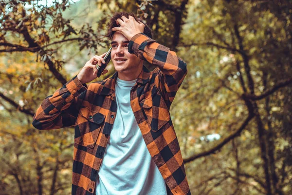 Sonbaharda dışarıda cep telefonuyla konuşan çocuk.