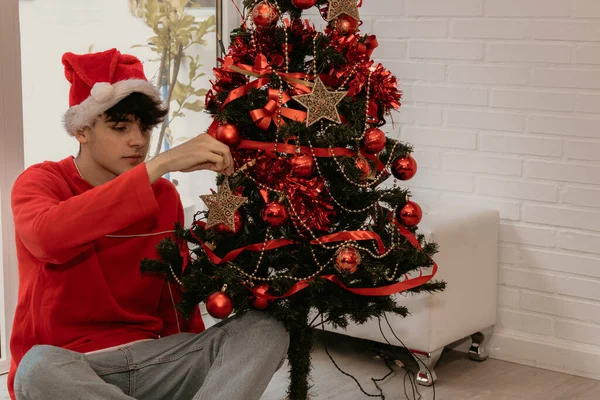 Menino Adolescente Decorando Árvore Natal Casa Com Chapéu Papai Noel — Fotografia de Stock