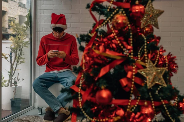 10代の若者がクリスマスに携帯電話を持って — ストック写真
