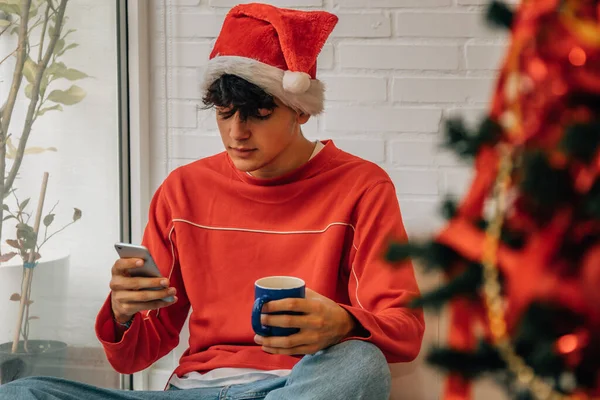 10代の若者がクリスマスに携帯電話を持って — ストック写真