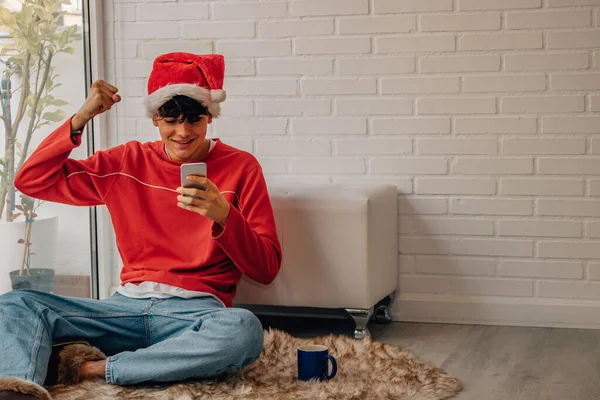 Έφηβος Αγόρι Στο Σπίτι Χριστούγεννα Ενθουσιασμένος Κοιτάζοντας Κινητό Τηλέφωνο — Φωτογραφία Αρχείου