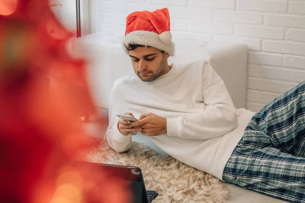 圣诞节期间 家里的男人用手机放松了下来 — 图库照片