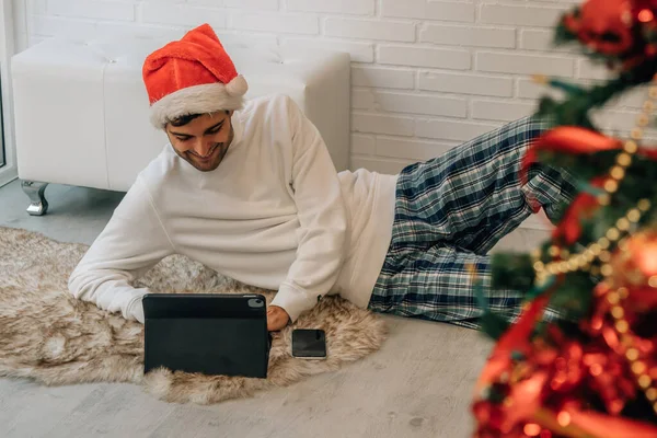 Homem Casa Natal Com Chapéu Papai Noel Com Computador Telefone — Fotografia de Stock