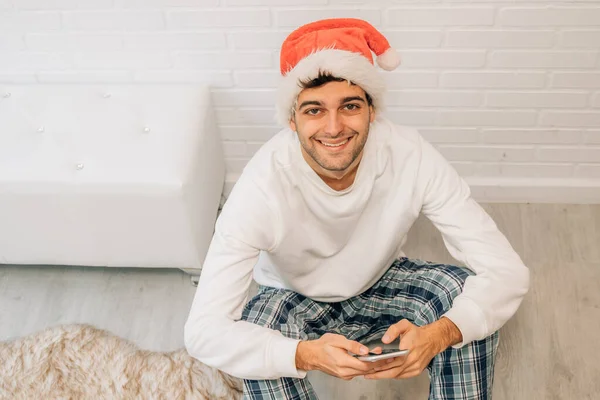 Mann Mit Handy Und Weihnachtsmann Mütze Hause — Stockfoto