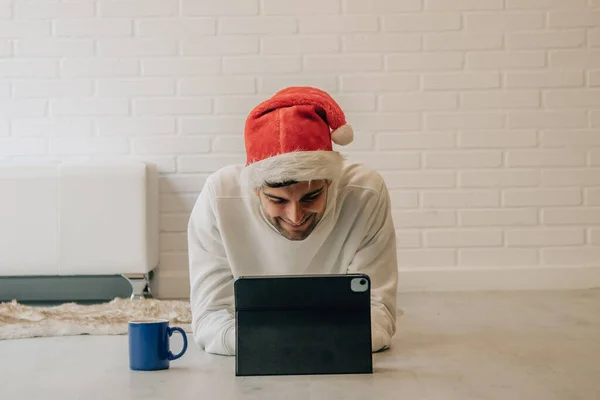 圣诞节的时候 家里拿着圣诞帽和电脑的男人 — 图库照片