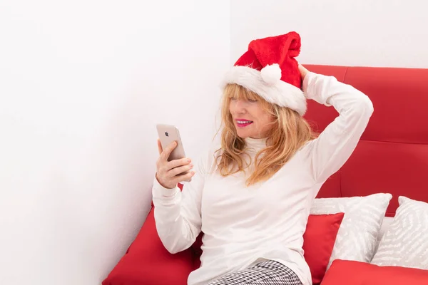 Женщина Рождество Дома Смотрит Мобильный Телефон — стоковое фото